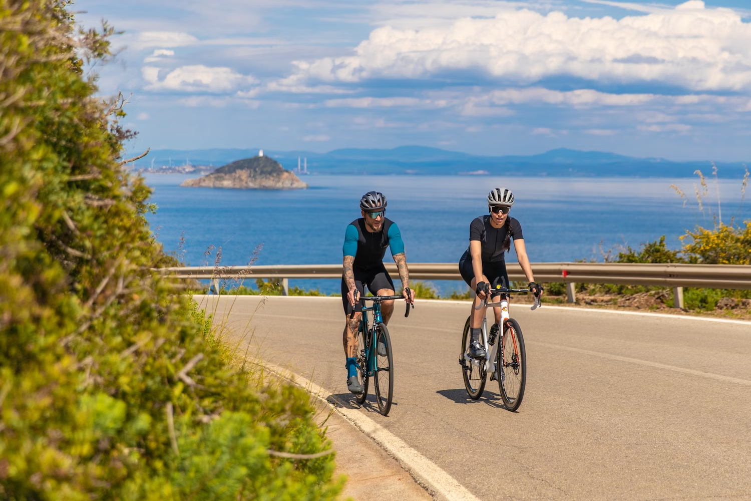Two cyclists riding on a coastal road